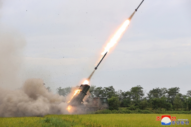 This photo, carried on Wednesday, shows the North test-firing a 240mm multiple rocket launcher with a new guidance system the previous day under the guidance of its leader Kim Jong-un. (KCNA)