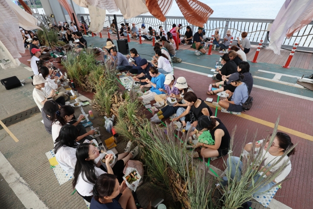 Participants gather for an art-dining performance at Jamsu Bridge, Seocho-gu, Seoul on Sunday. Dubbed 