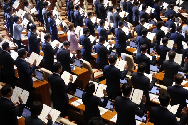 Members of the 22nd National Assembly are officially sworn in at the opening ceremony held in western Seoul on Monday. (Yonhap)