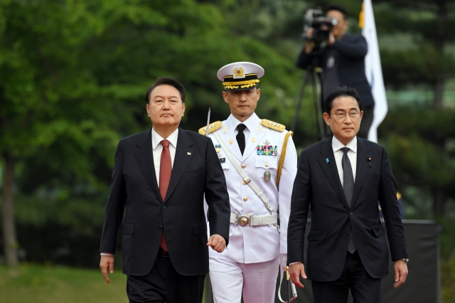 President Yoon Suk Yeol (left, front) and Japanese Prime Minister Fumio Kishida (right, front) walk along a red carpet during Kishida's visit to Seoul in May 2023 as Yoon received Kishida at his office. (Presidential office)