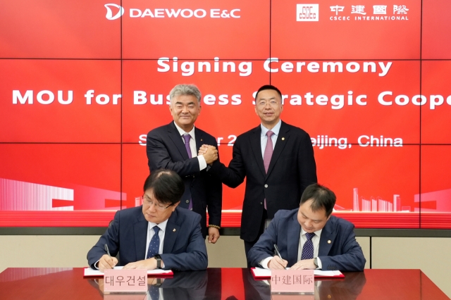 Daewoo E&C Chairman Jung Won-ju (left, back) shakes hands with CSCEC International Operations Chairman Gao Bo during a business agreement signing ceremony at the CSCEC headquarters in Beijing on Monday. (Daewoo E&C)