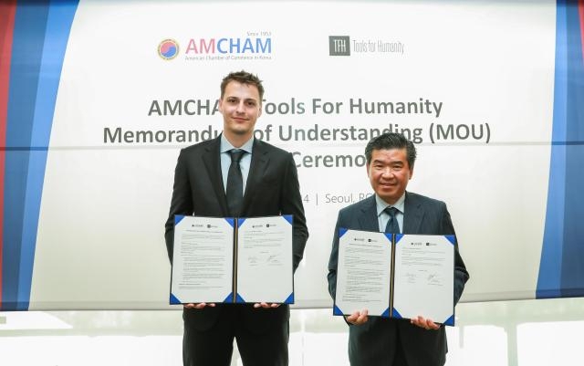 AmCham Chairman and CEO James Kim (right) and Tools for Humanity CEO and co-founder Alex Blania pose for photos at a signing ceremony event held in Seongsu-dong, eastern Seoul, Tuesday. (AmCham)