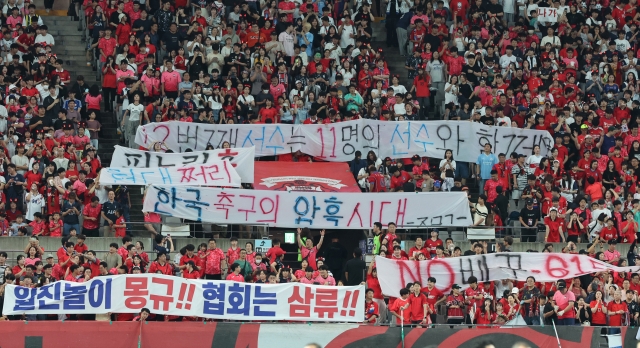 South Korean fans hold up banners criticizing Korea Football Association President Chung Mong-gyu and men's national team head coach Hong Myung-bo before South Korea's World Cup qualifier against Palestine at Seoul World Cup Stadium in Seoul on Thursday. (Yonhap)