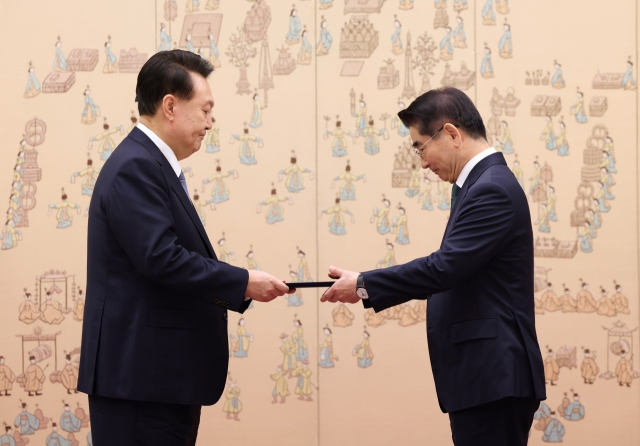 President Yoon Suk Yeol gives a certificate of appointment to Defense Minister Kim Yong-hyun during a ceremony at the presidential office in Seoul on Friday. (Yonhap)