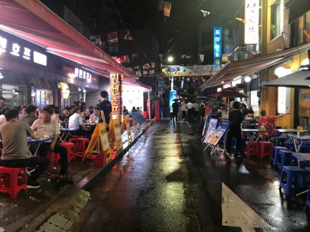 People sit outside restaurants in downtown Seoul. (Korea Herald file)