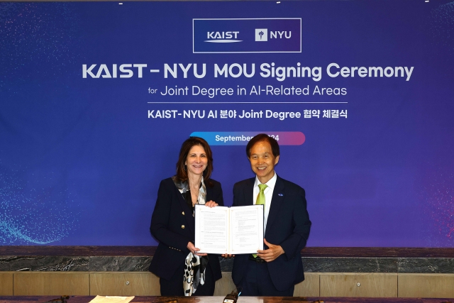 Linda Mills (left), president of New York University, and Lee Kwang-hyung, president of KAIST, pose for photo after signing an memorandum of understanding on joint degrees in artificial intelligence, in Seoul, Monday. (KAIST)