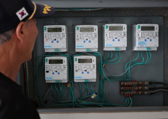 A person looks at an electric meter on Monday, as electricity bills rose 13 percent on average in August following record-breaking heat waves. (Yonhap)