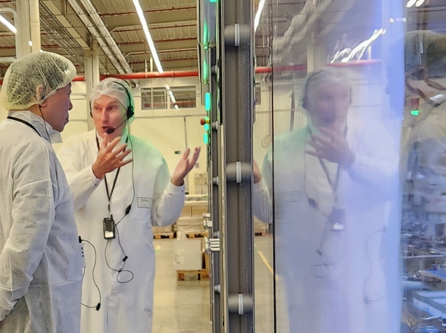 Lotte Group Chairman Shin Dong-bin (left) tours the Guylian chocolate production facility in Belgium in early September. (Lotte Group)