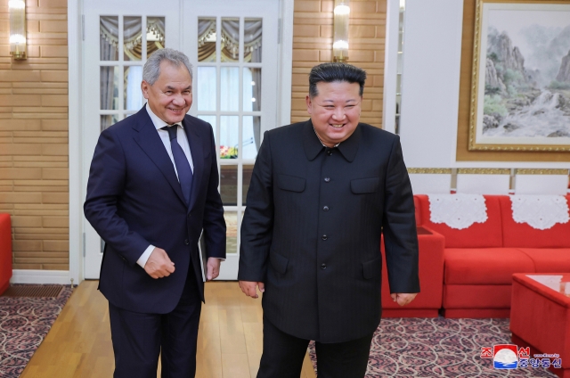 North Korean leader Kim Jong-un (right) talks with Sergei Shoigu, secretary of Russia's Security Council, in Pyongyang on Friday in this photo carried by the North's official Korean Central News Agency the following day. (Yonhap)