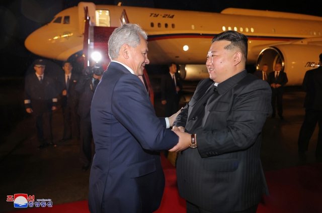 North Korean leader Kim Jong-un (right) shakes hands with Sergei Shoigu, secretary of Russia's Security Council, in Pyongyang on Friday in this photo carried by the North's official Korean Central News Agency the following day. (Yonhap)