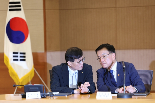 Bank of Korea Gov. Rhee Chang-yong (left) and Finance Minister Choi Sang-mok converse during a macroeconomics and finance meeting with other top finance officials in Seoul on Thursday. (Newsis)