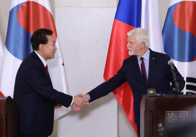 President Yoon Suk Yeol (left) and his Czech counterpart Petr Pavel shake hands at a press conference held in Prague Castle in Prague, Thursday. (Yonhap)