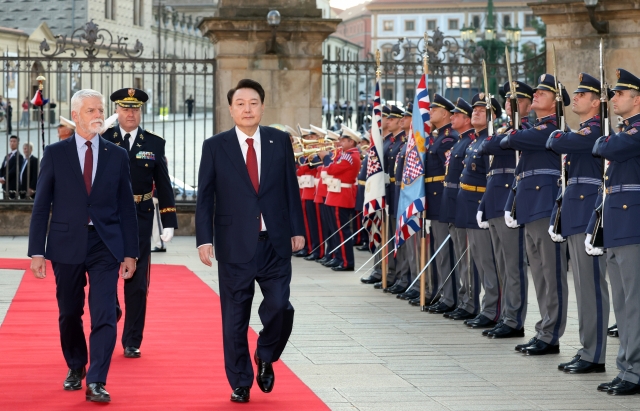 President Yoon Suk Yeol (second from left, front) and Czech President Petr Pavel (left, front) walk on a red carpet in Prague Castle in Prague as Yoon is on the official visit to the Czech Republic Thursday. (Yonhap)