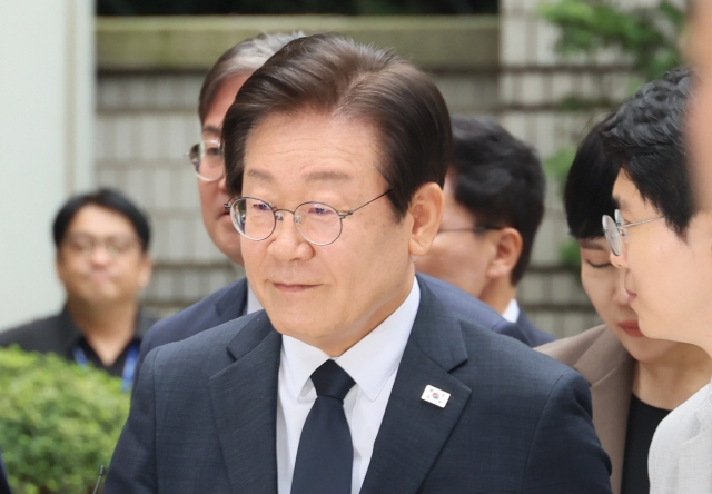 Lee Jae-myung, leader of the main opposition Democratic Party, is surrounded by reporters upon arriving at the Seoul Central District Court in the capital on Friday to attend the final hearing on his alleged election law violations for making false statements during his presidential campaign in 2021. (Yonhap)