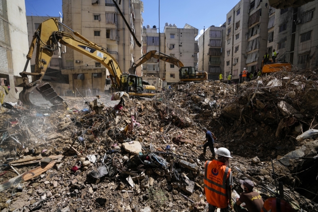 Emergency workers use excavators to clear the rubble at the site of Friday's Israeli strike in Beirut's southern suburbs, Lebanon, Monday. (AP-Yonhap)