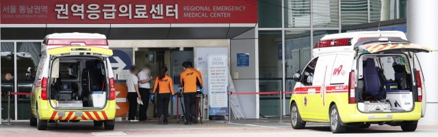 Paramedics wheel a patient into the emergency room of a Seoul-based hospital on Sunday. (Yonhap)