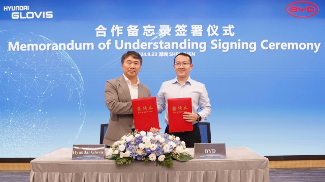 Kim Tae-woo (left), managing director of the shipping division at Hyundai Glovis, and Wang Junbao, general director of the corporate division at BYD, shake hands at the signing ceremony held at BYD headquarters in Shenzhen, Guangdong Province, China on Monday. (Hyundai Glovis)