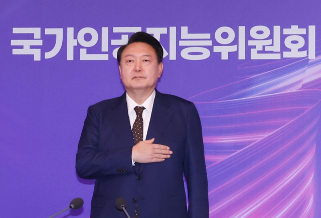 President Yoon Suk Yeol salutes to the national flag as he presided over the inaugural meeting of Presidential Committee on AI held at Four Seasons Hotel in Seoul Thursday. (Yonhap)