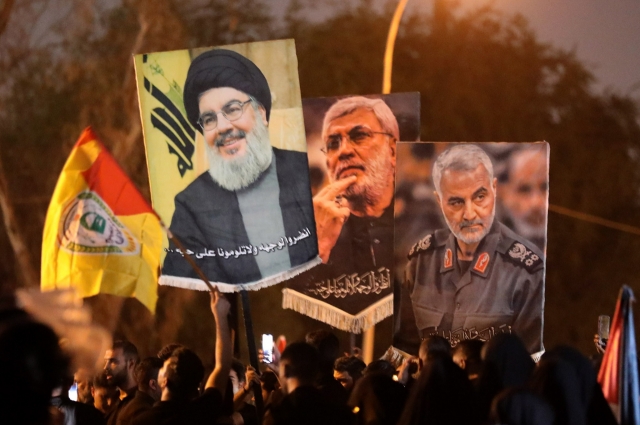 Supporters of the Hezbollah Brigades, an Iraq-based Shiite militia group ideologically aligned with Lebanon's Hezbollah, carry pictures of late Hezbollah leader Hassan Nasrallah, late deputy of Iraq's Popular Mobilization Forces Abu Mahdi al-Muhandis and late top Iranian commander Qasem Soleimani, during a protest against the killing of Nasrallah, near the entrance to the Green Zone in central Baghdad, Iraq, Saturday. (EPA-Yonhap)