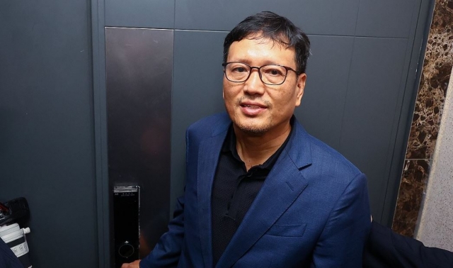 In this file photo from Aug. 1, 2024, Qoo10 CEO Ku Young-bae opens the door to his home as prosecutors prepare to raid his place as part of their investigation into financial trouble of Qoo10 affiliates TMON and WeMakePrice. (Yonhap)