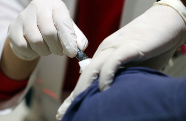 A healthcare worker administers a flu vaccine to a patient at a clinic in Seoul on Oct. 30, 2020. (Yonhap)