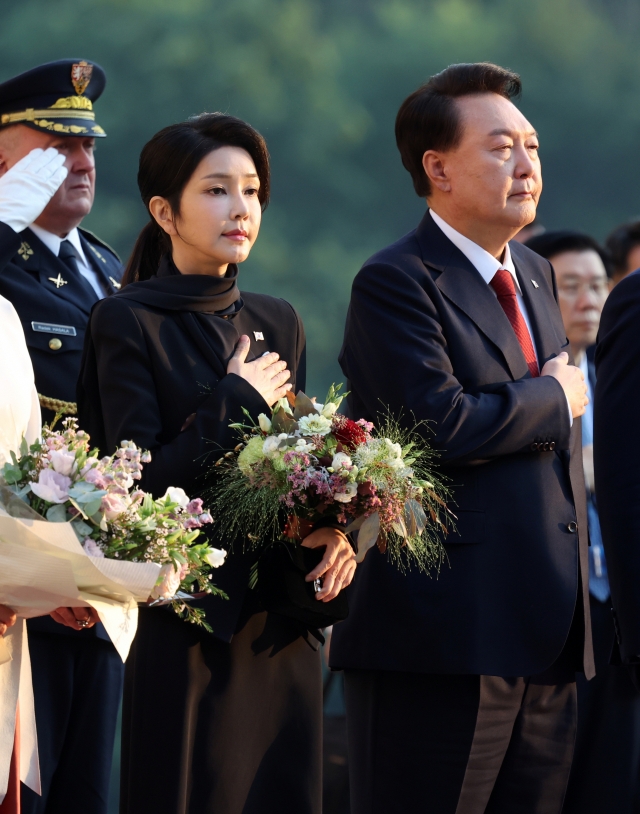 President Yoon Suk Yeol (right, front) and first lady Kim Keon Hee (left, front) salute to the national flag during the summit in Prague with Czech President Petr Pavel on Sept. 19. (Yonhap)