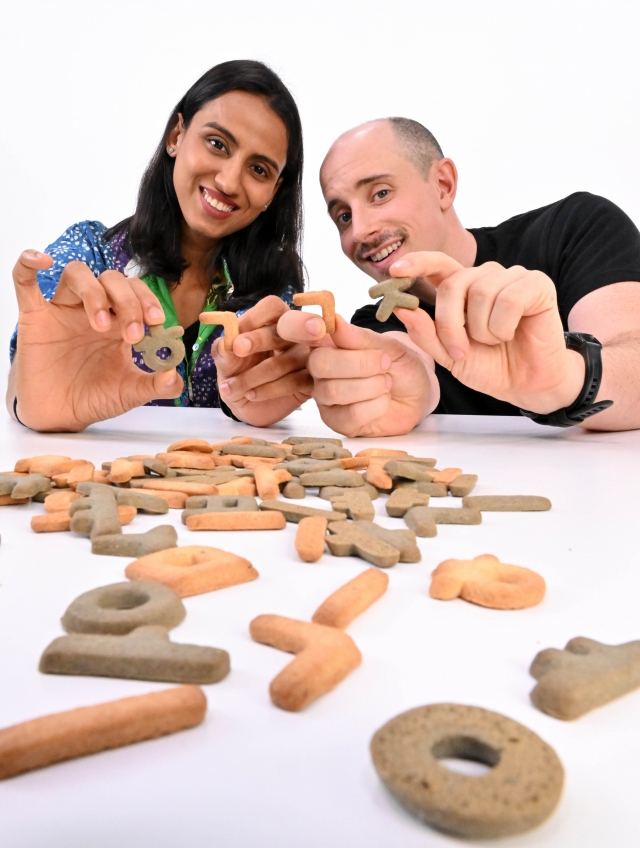 Tyler Rasch (right) and Nidhi Agrawal pose with Hangeul Kwaja, Korean alphabet-shaped cookies, prior to an interview with The Korea Herald Sept. 25 in Seoul. (Im Se-jun/The Korea Herald)