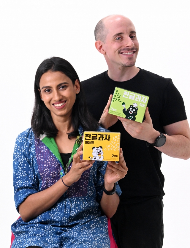 Tyler Rasch (right) and Nidhi Agrawal pose with Hangeul Kwaja, Korean alphabet-shaped cookies, prior to an interview with The Korea Herald Sept. 25 in Seoul. (Im Se-jun/The Korea Herald)