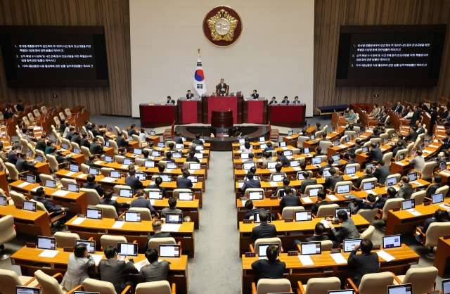 Both ruling and opposition lawmakers participate in a revote for the three contentious bills railroaded by the Democratic Party of Korea and vetoed by Yoon earlier this week at the National Assembly on Friday. (Yonhap)