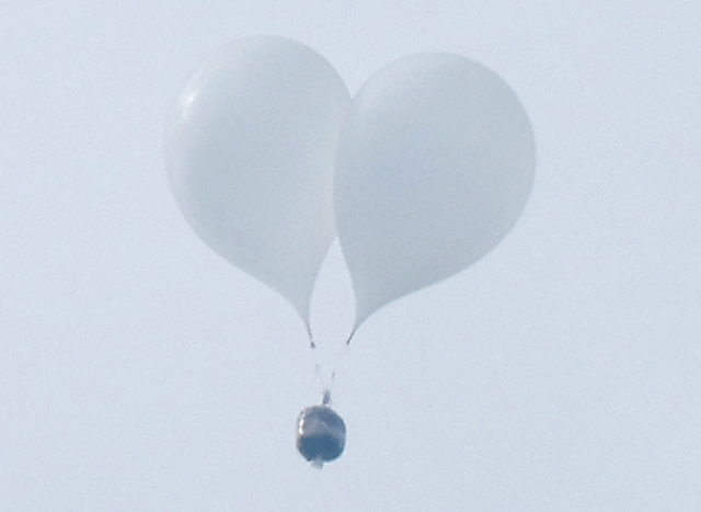 Balloons sent by North Korea, thought to be carrying garbage, are seen flying above Seoul on Monday. (Yonhap)