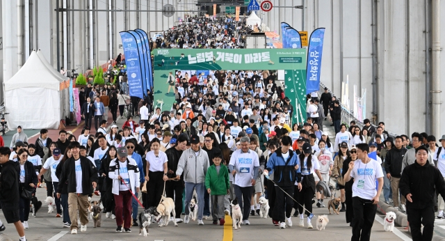 Participants of the Slow Marathon With Pets and their companions, including Seoul Mayor Oh Se-hoon, Daewoo E&C Chairman Jung Won-ju, who doubles as chairman of Herald Media Group, walk along Banpo Bridge in southern Seoul during the inaugural Wellness Seoul 2024 festival on Sunday. (Im Se-jun/ The Korea Herald)