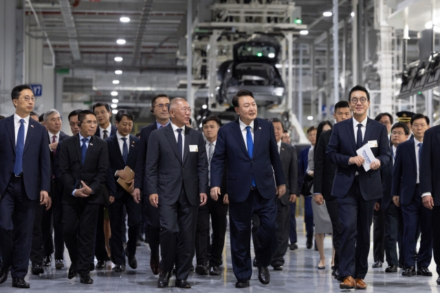 President Yoon Suk Yeol (center right) and Hyundai Motor Executive Chair Chung Euisun visit the production facility of Hyundai Motor Group Innovation Center Singapore in Singapore's Jurong Innovation District on Tuesday. (Yonhap)