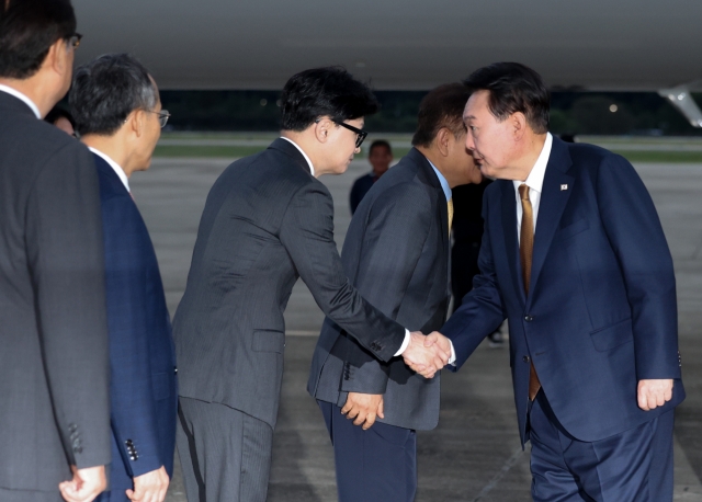 President Yoon Suk Yeol (right) shakes hands with Han Dong-hoon, leader of the ruling People Power Party, on Sept. 19, 2024, as Yoon departs for the Czech Republic at Seoul Air Base in Seongnam. (Yonhap)