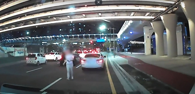 A pregnant woman in Busan approaches police officers in a patrol car to request help on Sept. 12, in this video posted on the official YouTube channel of the Busan police. (Busan Metropolitan Police Agency)