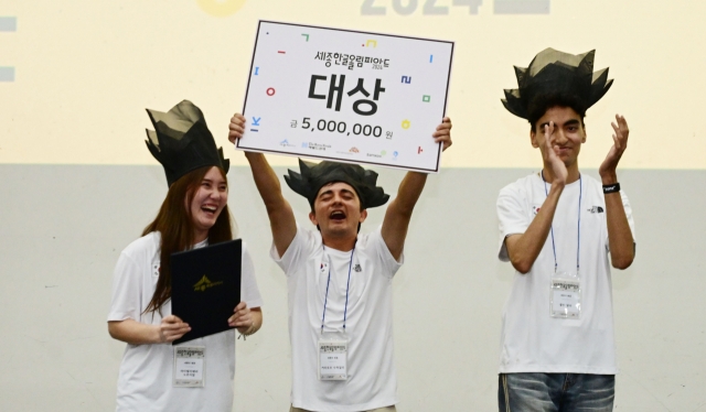 Aitalieva Nurzhamal (from left), from Kyrgyzstan, Karimov Suhaili, from Tajikistan and Hartane Alaa, from Morocco, pose for a photograph after receiving the grand prize at the Sejong Hangeul Olympiad held on Tuesday. (Park Hae-mook/The Korea Herald)