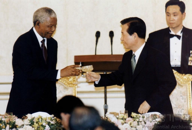 In this file photo, South Korean President Kim Dae-jung (center), speaks with Nelson Mandela, former president of South Africa, at a dinner banquet at the presidential office in Seoul in 2001. (Presidential archives at Ministry of the Interior and Safety)