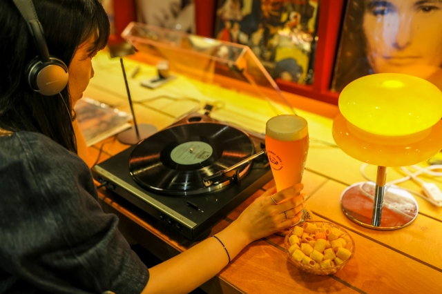 A visitor listens to a vinyl record with a glass of beer at Jinju Jinmac Beer Brewery in Jinju, South Gyeongsang Province. (Korea Tourism Organization)