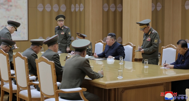 This photo, carried by North Korea's official Korean Central News Agency on Tuesday, shows the North's leader Kim Jong-un (3rd from right) convening a consultative meeting on national defense and security the previous day to discuss ways to respond to South Korean drones' alleged flights over Pyongyang. (Yonhap)