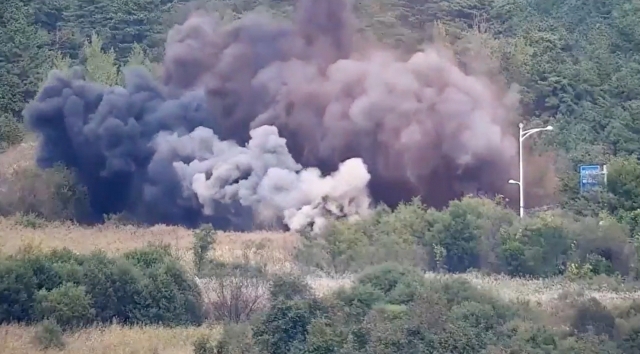 A cloud of smoke and dust is seen rising from an inter-Korean road near the east coast after North Korean authorities demolished parts of inter-Korean road connections on Tuesday. (Yonhap)