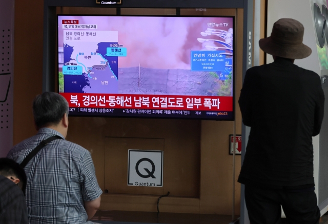 People watch a news report on North Korea's explosion of inter-Korean roads at Seoul Station on Tuesday. (Yonhap)