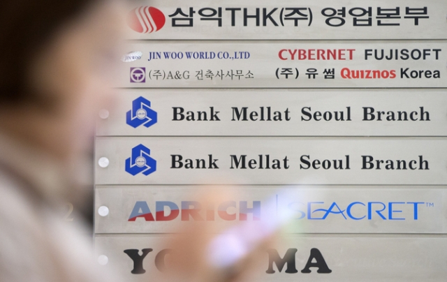 A passerby walks in front of a Bank Mellat Seoul Branch logo featured at the lender's office in southern Seoul. (Yonhap)