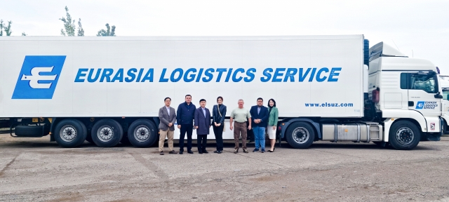 Hanjin Logistics CEO Noh Sam-sug (third from left) and President and Chief Marketing Officer Emily Cho (center) pose for a photo with other officials in front of an Eurasia Logistics Service truck in Uzbekistan. (Hanjin Group)