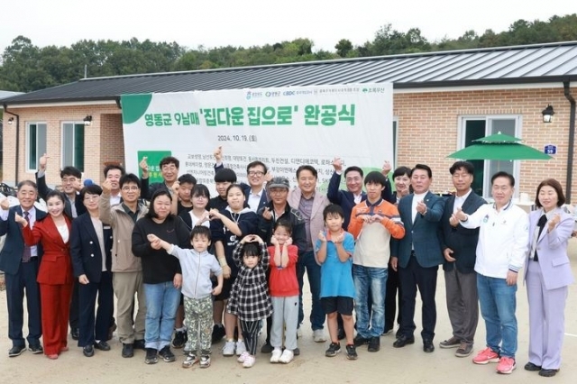 North Chungcheong Governor Kim Young-hwan and other officials celebrate the completion of a new home for the family of nine siblings. (North Chungcheong Provincial Office)