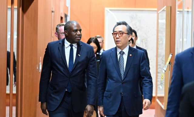 Foreign Minister Cho Tae-yul (right) and British Foreign Secretary David Lammy walk into a conference room to hold their strategic dialogue at the foreign ministry in Seoul on Monday. (The foreign ministry)