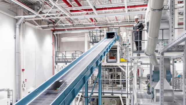 Used battery modules glide along a conveyor belt towards a massive shredder (Mercedes-Benz)