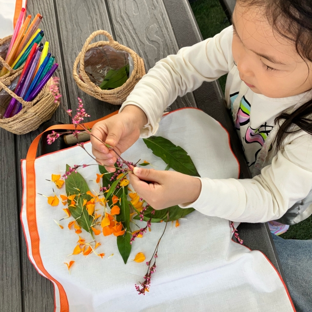 A child makes an apron with flowers at Flower Jay farm. (Kim Da-sol/The Korea Herald)