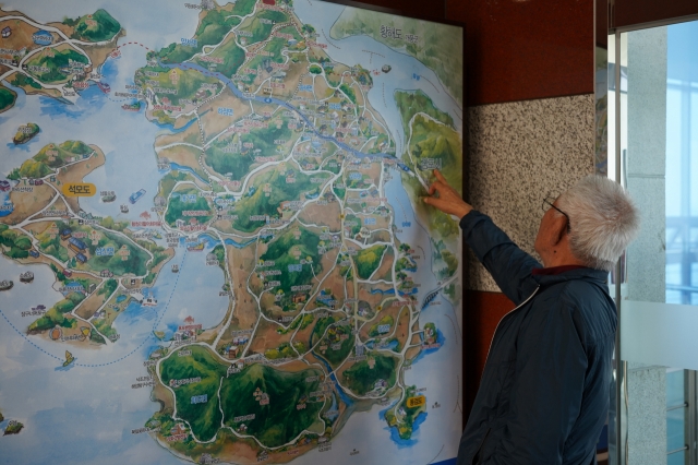 A local bus tour participant locates Ganghwa Peace Observatory on a map. (Lee Si-jin/The Korea Herald)