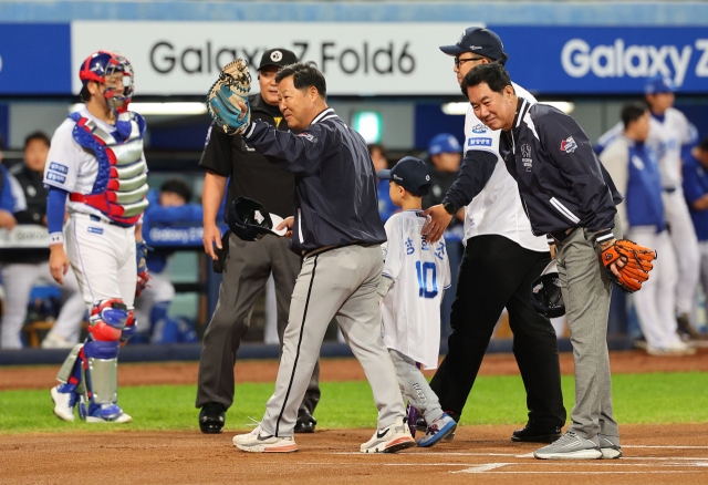 Former Samsung Lions catcher Lee Man-soo (center) and pitcher Kim Si-jin (right) acknowledge fans after participating in a pregame ceremony before Game 3 of the Korean Series at Daegu Samsung Lions Park in Daegu, 235 kilometers southeast of Seoul, Friady. (Yonhap)