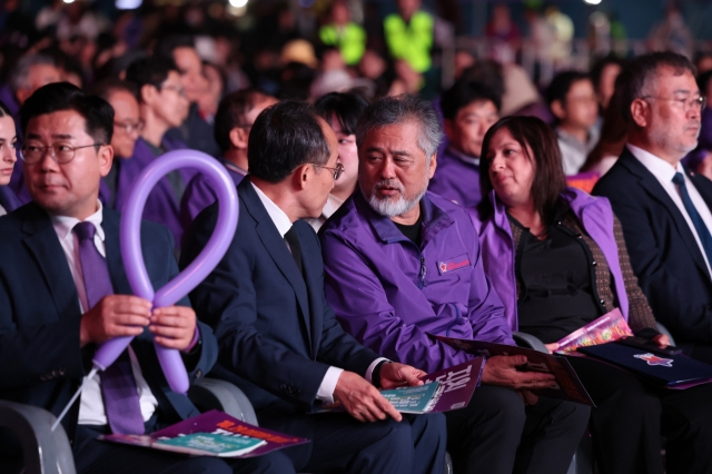 Ruling People Power Party floor leader Choo Kyung-ho (2nd from left) speaks with Lee Jeong-min (center), head of the group representing the bereaved families of the victims of the 2022 Itaewon crowd crush that claimed 159 lives during Halloween celebrations, at a memorial event in front of Seoul City Hall marking the tragedy's second anniversary, on Saturday. (Yonhap)