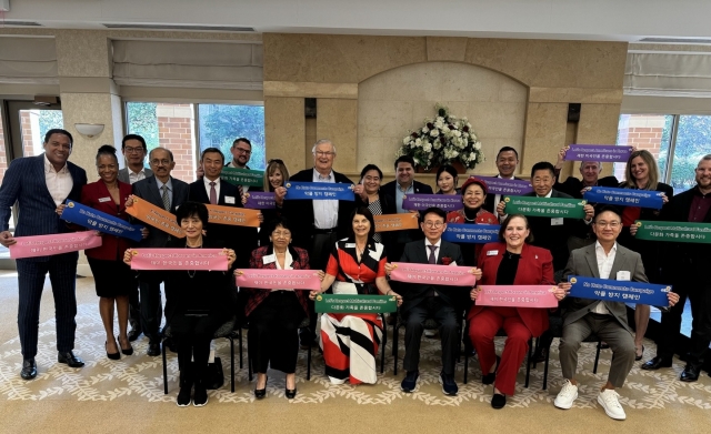 Northern Illinois University President Lisa C. Freeman (front, third from left) and Sunfull Foundation Chair Min (front, fourth from left) pose with professors, school officials and alums during the 